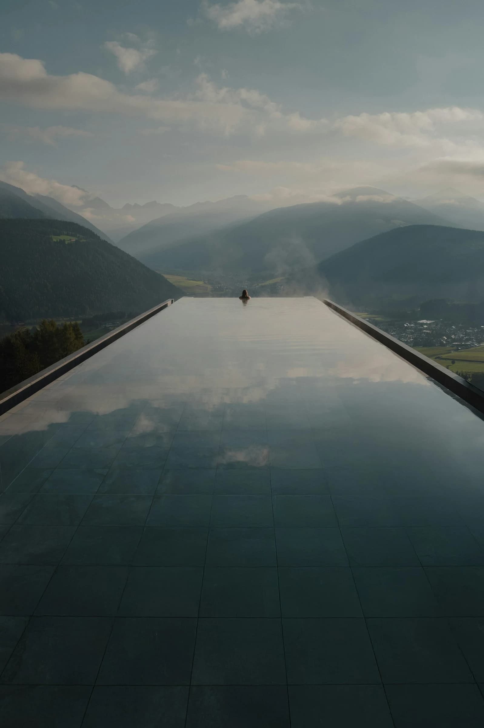 Infinity pool dissolving into a still horizon at dusk